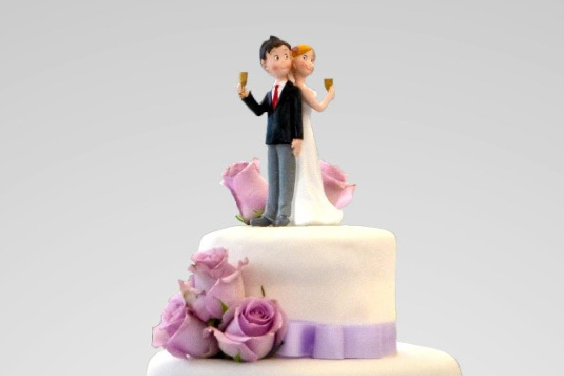 A wedding couple on top of the cake
